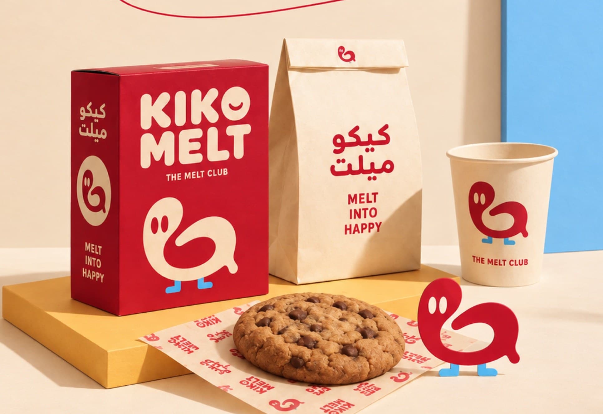 Kiko Melt packaging on a cream ground: a red cookie box, a paper bag in Arabic and English, a cup carrying the Loop bird, and a chocolate chip cookie on branded wrap