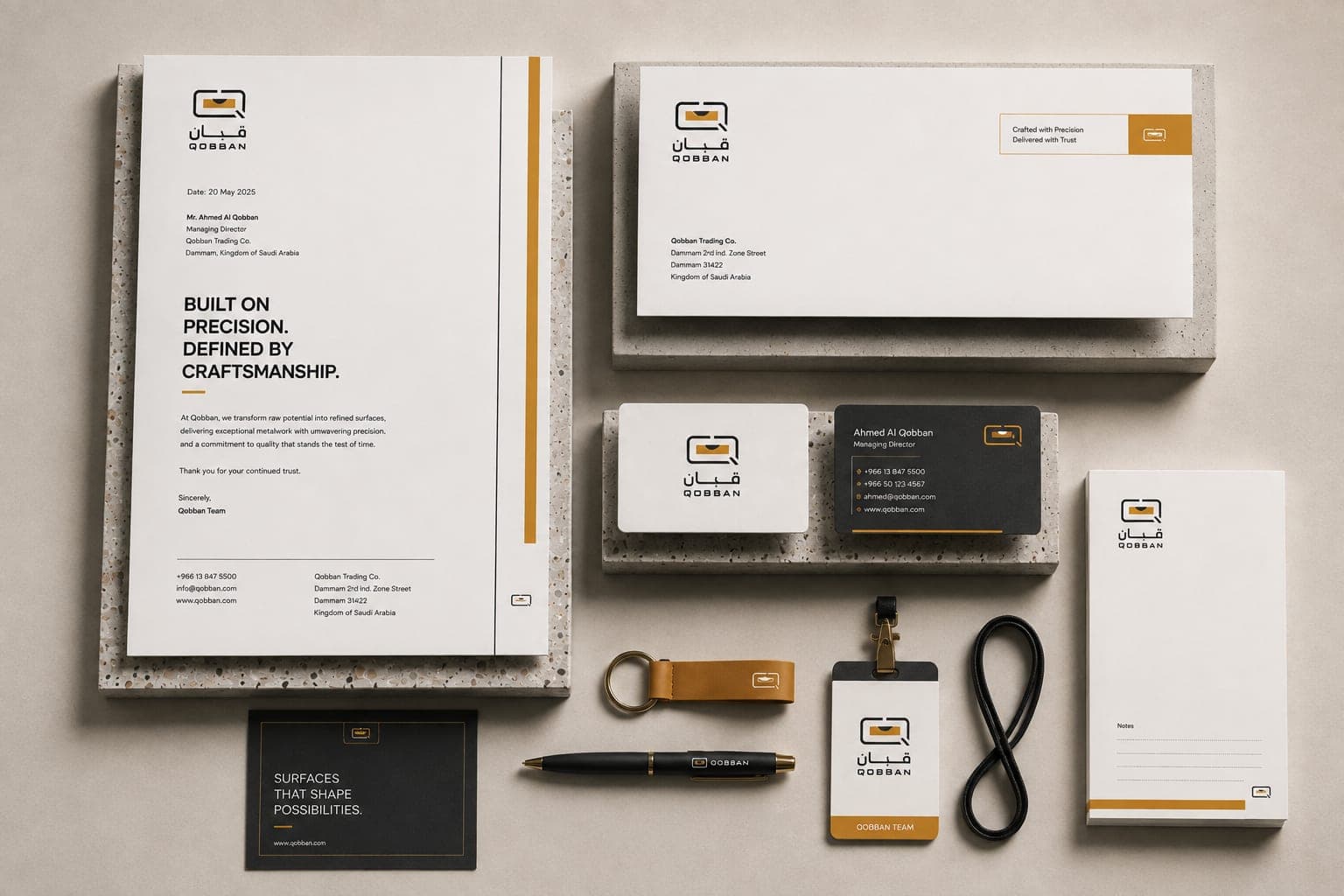 The Qobban stationery set laid out — letterhead, envelope, business cards, notepad, pen, keyring and lanyard