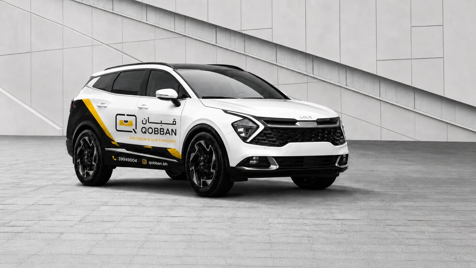 A white Qobban SUV in the company livery, its mark and phone number along the door
